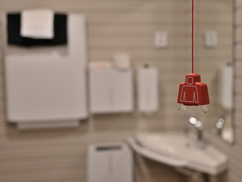 Esteetöntä wc-tilaa ja edessä punainen hälytysnaru.