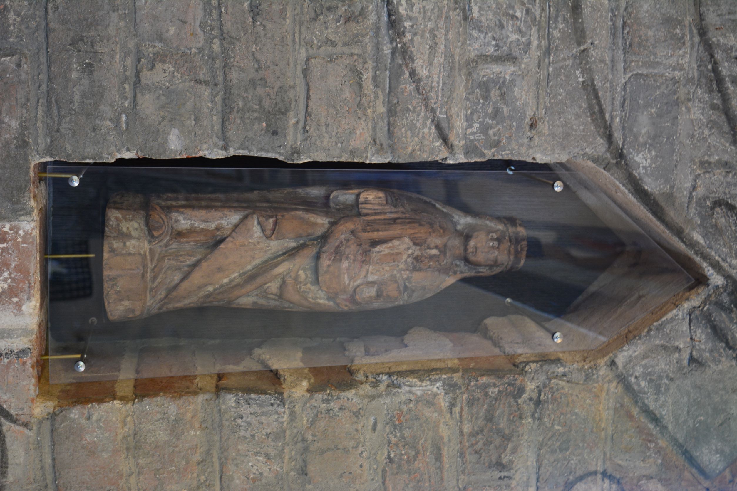 Tiilistä tehdyn pilarin syvennyksessä on pienehkö puinen patsas naishenkilöstä. Patsas on kulunut ja sen kädet puuttuvat.