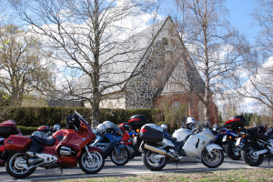 Moottoripyöriä Liedossa tiellä taustalla Liedon kirkko.