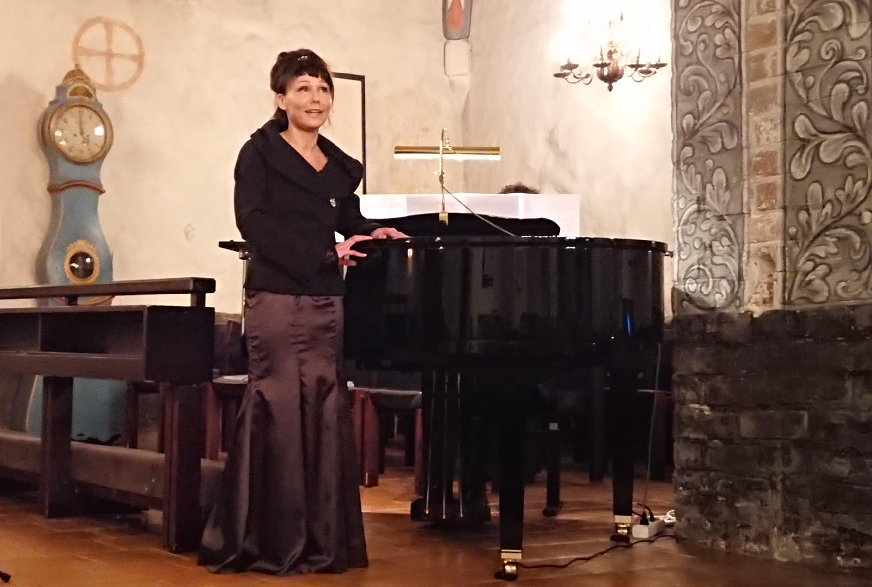 Liedon seurakunnan kanttori, sopraano Svetlana Jääskeläinen, laulaa Liedon kirkossa, flyygelin edustalla
