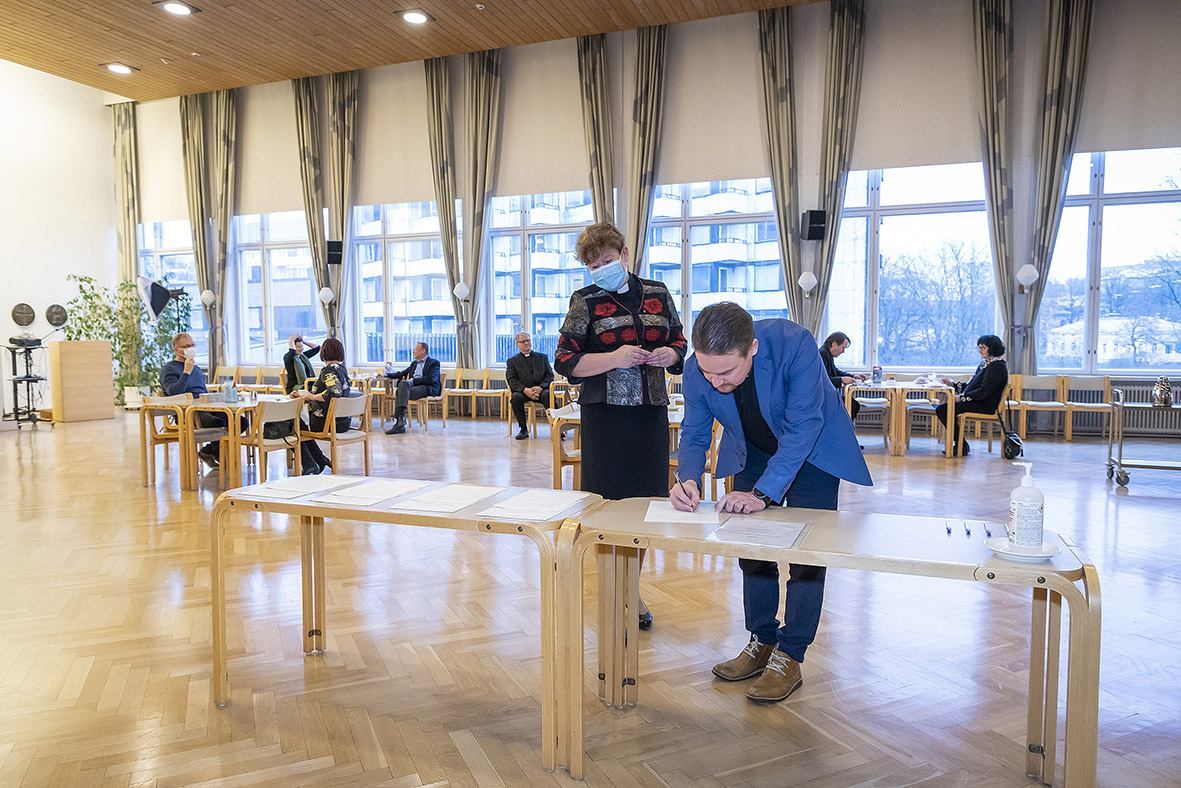 Kirkkoherra Risto Leppänen allekirjoittamassa sopimusta vierellään keskusrekisterin johtaja Hanna Lehto.