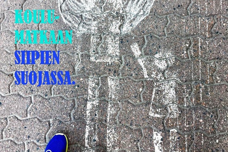 kuvassa katuun liidulla hahmoteltu enkeli ja lapsi käsikkäin. Alareunassa näkyvät lisäksi aikuisen ja lapse...