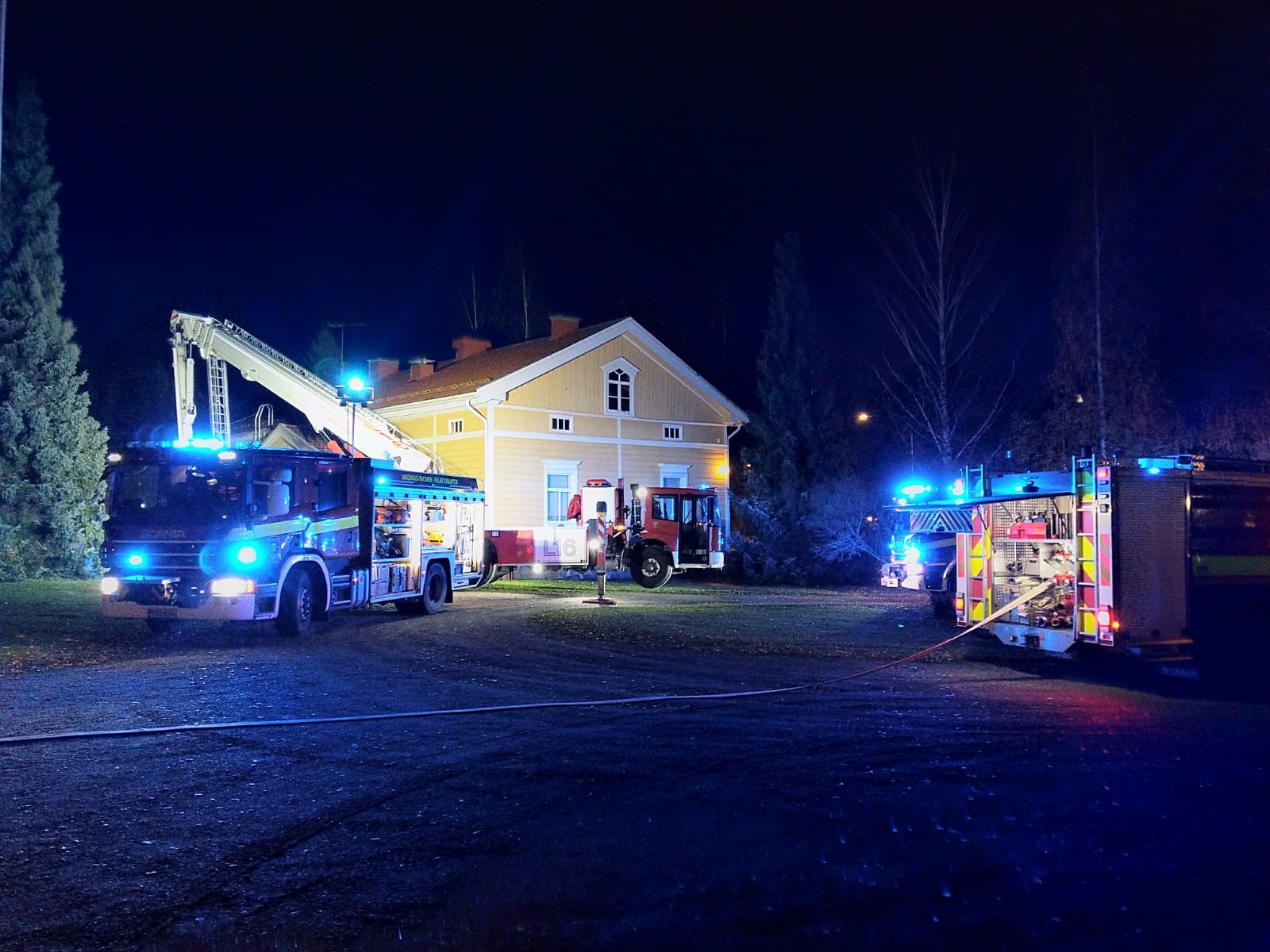 Paloautoja Liedon pappilan pihalla yöllä ja pelastustyöt käynnissä.