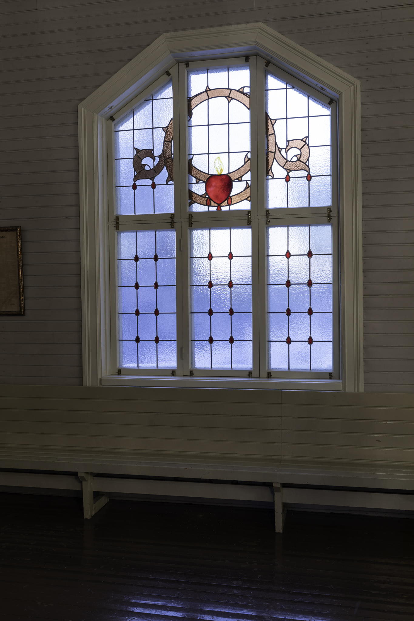 Ikkunan yläosaan maalattu orjantappurakruunu sekä sydän ja  alaosassa ruudukkoa jossa punaisia veripisaroita joita myös yläosan kuvassa.
