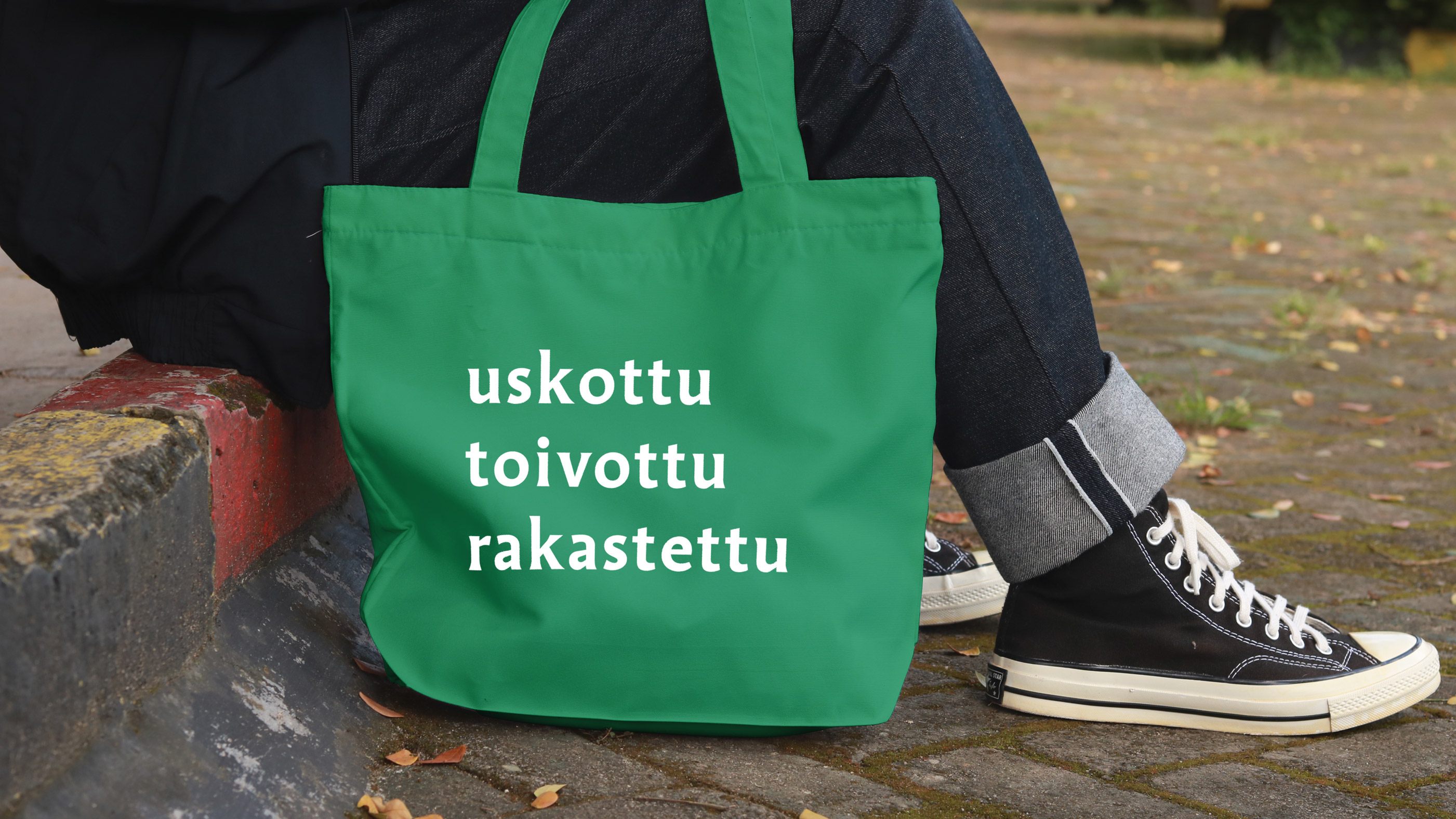Vihreä kassi, jossa valkoisella sanat 
